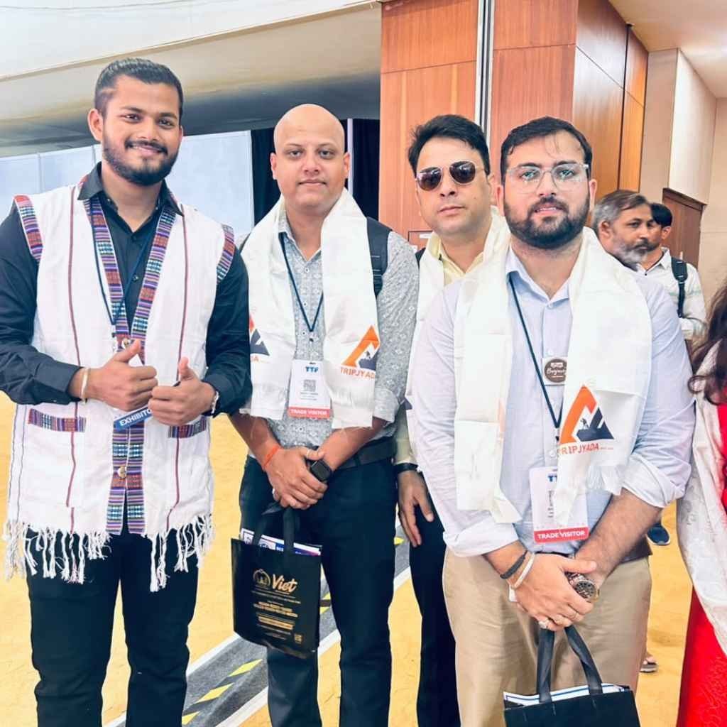 Tripjyada representatives wearing white scarves at a travel event