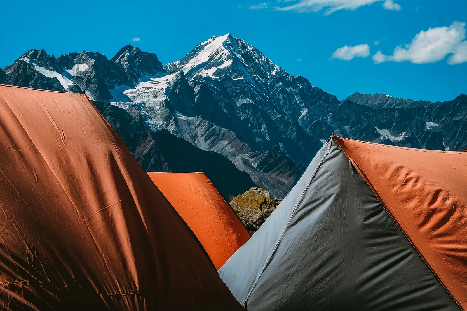 Backpacking tents pitched beneath snowy Himalayan mountains