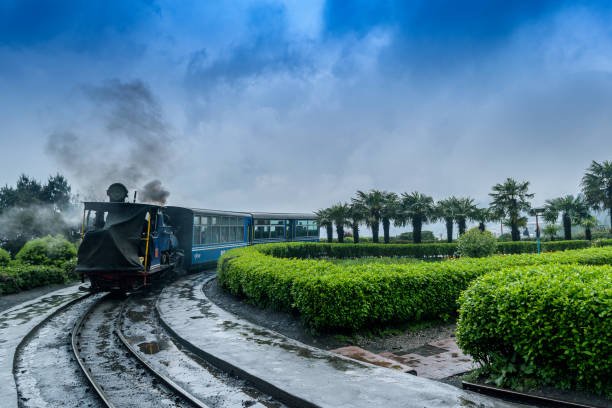 May 01,2017.The Darjeeling Himalayan Railway, also known as the Toy Train, is a 2 ft narrow gauge railway,is entering to the Batasia loop,Darjeeling, west bengal, India. after a heavy rainfall.